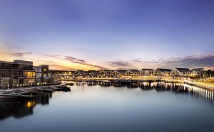 Under the beautiful, colourful evening sky, the lights from the buildings on the Boardwalk at Friday Harbour reflects off the waters of the Marina.